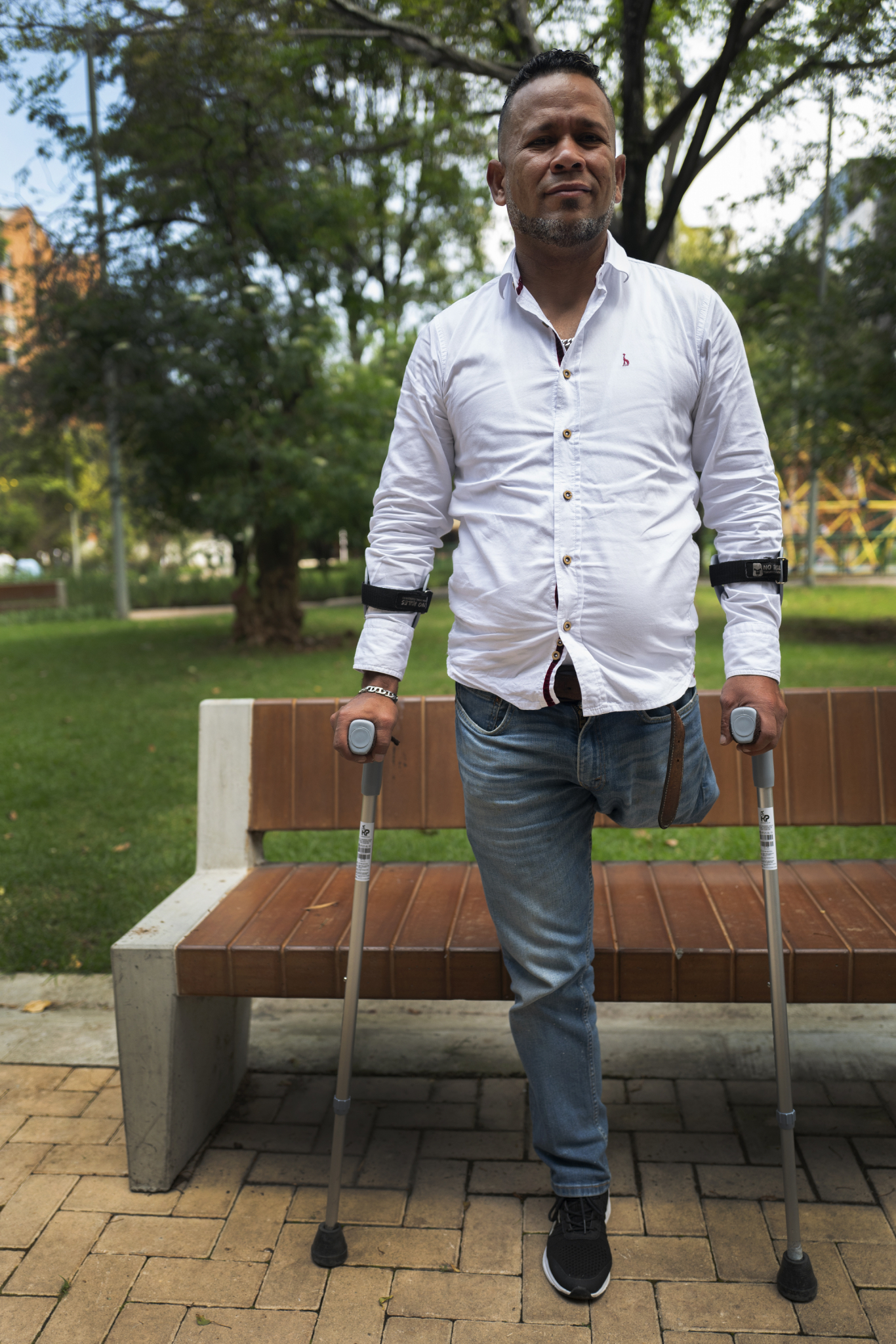 Venezuelan man stands with one leg amputated, crutches in hand