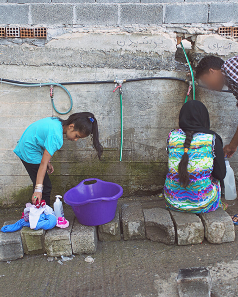 Habib Draws Water From Camp Hoses In Greece