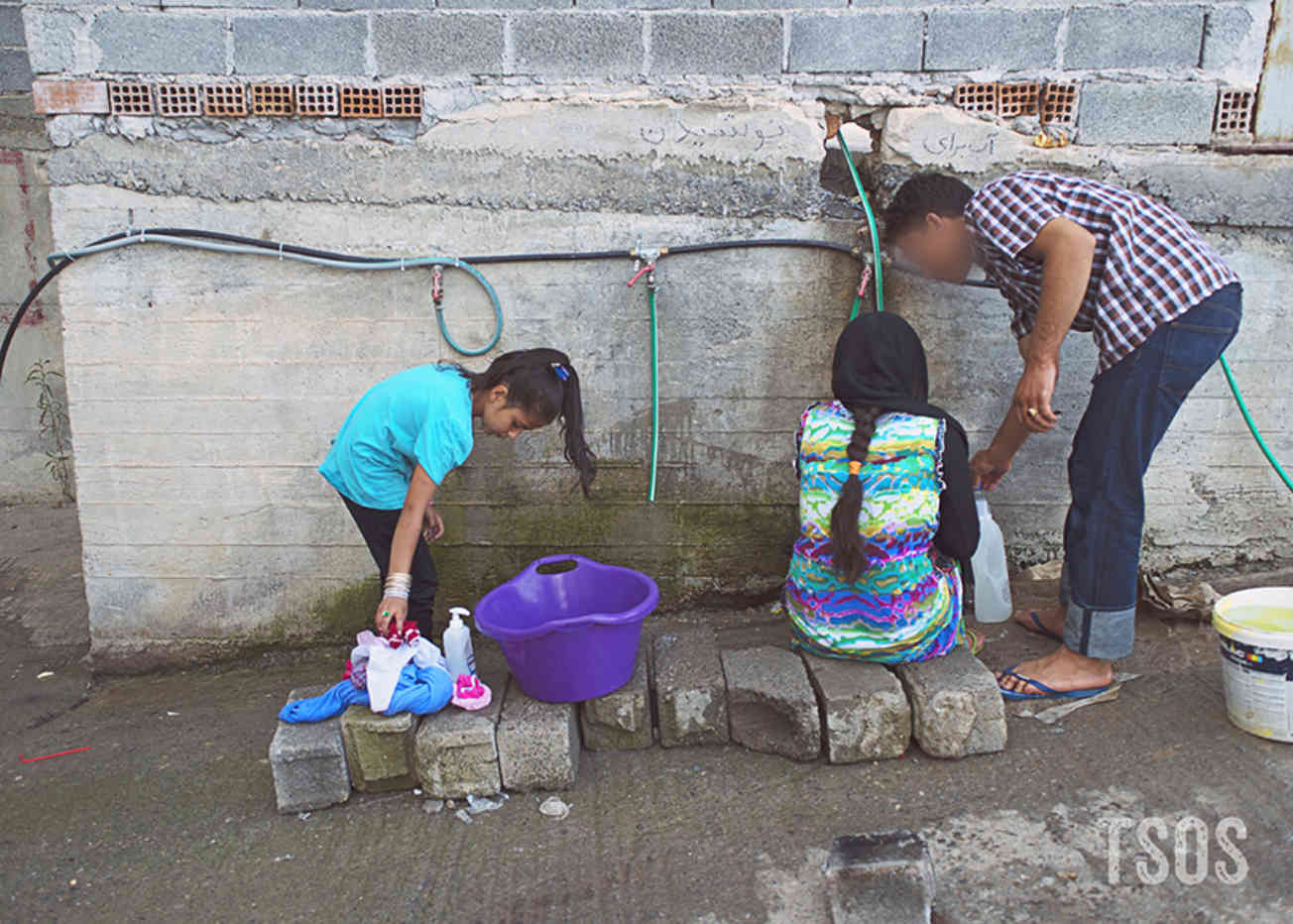 Habib Draws Water From Camp Hoses In Greece